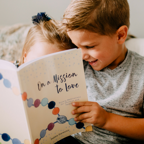 Little boy and girl reading On a Mission to Love Book