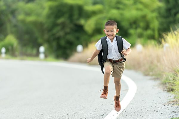 smiling, running young boy student in uniform