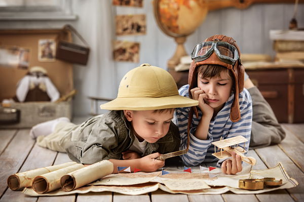 2 explorer boys with map and magnifying glass